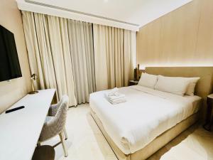 迪拜FIVE Palm Jumeirah Resort - 2 Bedrooms plus Maids and Private Jacuzzi - ModernLux的一间卧室配有一张床、一张书桌和一台电视