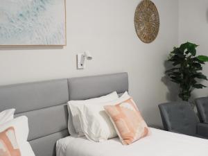 华纳海湾海滨大道汽车旅馆的一间卧室配有带白色和粉红色枕头的床