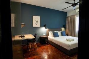 吉隆坡Bukit Damansara by Plush的一间卧室配有一张床、一张桌子、一张床和一张书桌