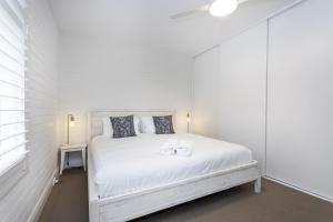 珀斯Cottesloe Beach View Apartment - EXECUTIVE ESCAPES的白色的卧室设有白色的床和窗户。
