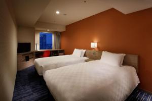 东京池袋阳光城王子酒店的酒店客房设有两张床和电视。