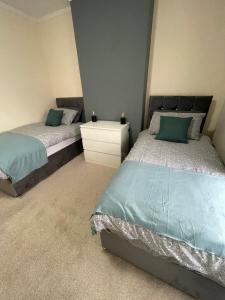 克鲁Bentley Place的一间卧室设有两张单人床和一个床头柜。