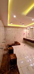 麦加Al Ebaa Hotel的一间铺有大理石地板并配有水槽的大浴室