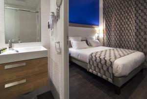 马赛加雷老港酒店的一间卧室配有床、水槽和镜子