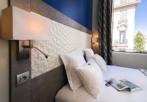 马赛加雷老港酒店的卧室配有带白色枕头的床和窗户。