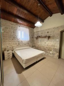 莫迪卡Villa Sikè的一间卧室设有一张床和石墙