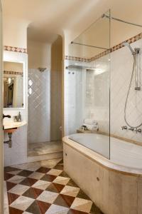 菲利内瓦尔达诺Palagina la dimora的带浴缸和玻璃淋浴间的浴室。