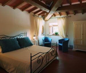 菲利内瓦尔达诺Palagina la dimora的一间卧室配有一张床和两张蓝色椅子