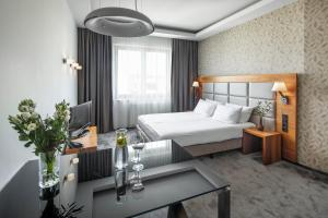 格丁尼亚Sea Premium Apartments的酒店客房配有一张床铺和一张桌子。