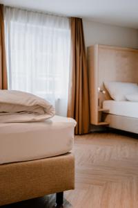 阿尔邦Hotel Müllers Self-Check-In的一间卧室设有两张床和窗户。