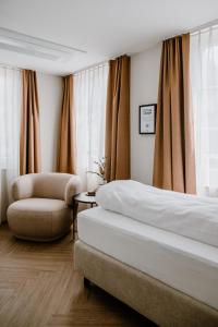 阿尔邦Hotel Müllers Self-Check-In的配有一张床和一把椅子的酒店客房