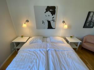 维斯比Hamngatan Logi的一间卧室配有一张带蓝色床单的床和两张桌子