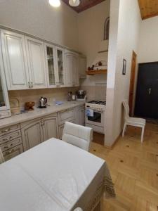 苏呼米Квартира у моря в Абхазии Сухум的厨房配有白色橱柜和桌椅