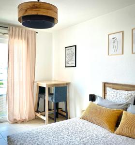 圣普斯特恩耶尔Appartement en face Hopital Nord的一间卧室配有一张床、一张桌子和一张书桌