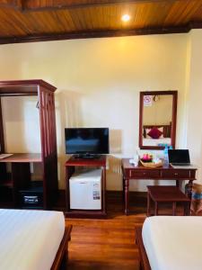 琅勃拉邦Luang Prabang Maison Vongprachan & Travel的一间卧室配有书桌、一张床和镜子