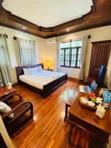 琅勃拉邦Luang Prabang Maison Vongprachan & Travel的一间卧室设有一张大床,铺有木地板