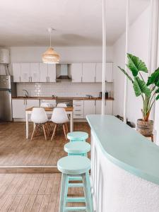 科拉雷侯GreenTree House的厨房配有白色橱柜、蓝色柜台和凳子