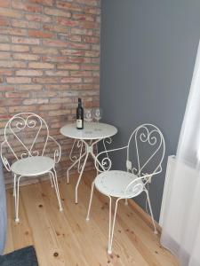 克雷尼察Apartament Rent Home的两把桌子和两把椅子,配酒杯和砖墙