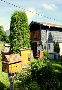 马林贝格Ferienhaus beim Imker的院子里有一间黄色鸟屋的房子