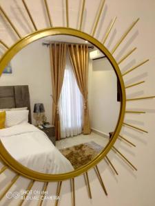 莱基HOMEDALES Freedom Way LEKKI Phase1 LAGOS的卧室里一张大金色镜子,卧室里配有一张床铺