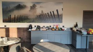 SarezzanoORIZZONTI Vigneti Repetto的厨房配有桌子,墙上挂有绘画作品