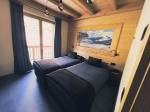 利维尼奥Carosello Lodge Livigno的小木屋内一间卧室,配有两张床