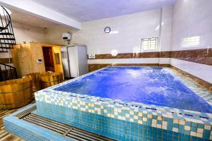 和平Hoa Viên Hotel - Suối khoáng Kim Bôi的一座铺有蓝色瓷砖地板的大型游泳池
