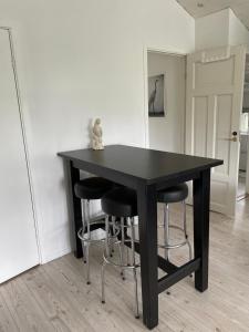 SöråkerVilla Båthamnsgatan的一张黑桌,里面放着四把凳子