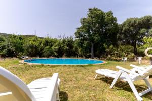 卡萨雷斯Finca Santa Teresa, Casa La Higuera的一组白色椅子和一个游泳池