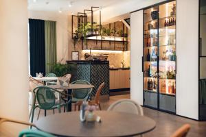 德鲁斯基宁凯乡田酒店及Spa的餐厅设有桌椅和装有葡萄酒的架子