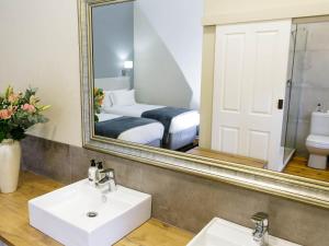 奥茨胡恩Queens Hotel by BON Hotels的一间带镜子、水槽和床的浴室