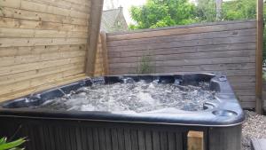 图尔奈B&B Aquavert & Wellness的后院的热水浴池,设有木栅栏