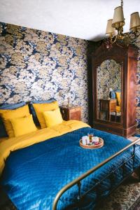 Étival-Clairefontainev i o l e t t e La souris des champs的一间卧室配有一张带蓝色毯子和镜子的床