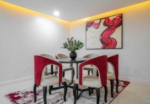 拉各斯Sapphire Heights Apartment的一间带桌椅和绘画的用餐室