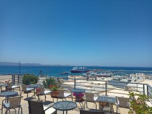 纳克索乔拉Naxos Illusion Nikos Verikokos的一个带桌椅的庭院和一个海港