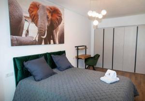 克卢日-纳波卡BG LUXIMMO APARTMENTS的一间卧室配有一张大象照片的床