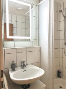 施科伊迪茨Helles und ruhiges Apartment direkt am Flughafen Leipzig Halle的浴室设有白色水槽和镜子