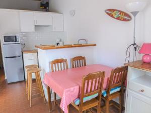 拉卡诺奥肯Holiday Home Les Palombes-7 by Interhome的厨房配有粉红色的桌椅和冰箱。