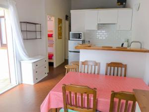 拉卡诺奥肯Holiday Home Les Palombes-7 by Interhome的厨房配有一张桌子,上面有红色的桌布