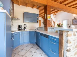 Hauteville-sur-MerHoliday Home Les Mouettes - HSM401 by Interhome的厨房配有蓝色橱柜和木制天花板
