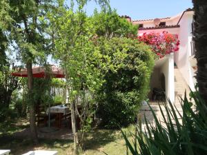拉宾Apartment Villa Palma - LBN405 by Interhome的一座花园,位于一座带桌子和鲜花的房子前