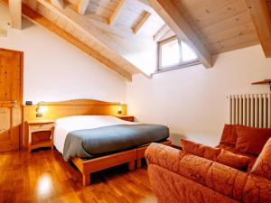 罗恩佐Apartment Pensione Villa Belfiore-2 by Interhome的一间卧室配有一张床和一张沙发
