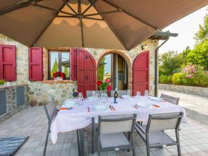 蒙泰卡蒂尼瓦尔迪切奇纳Holiday Home Girasole-2 by Interhome的一个带红色门的庭院里的桌椅