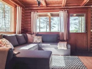 SoiniHoliday Home Haapala by Interhome的带沙发和2扇窗户的客厅