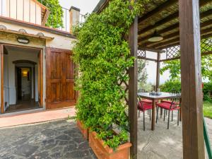雷杰洛Holiday Home Podere Berrettino-2 by Interhome的一个带桌子和绿 ⁇ 的房子的入口