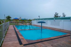 MundraHotel Surbhi的中间的游泳池配有遮阳伞
