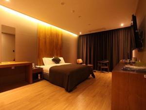 高阳市里奇酒店的一间酒店客房,一间设有一张床和一张书桌