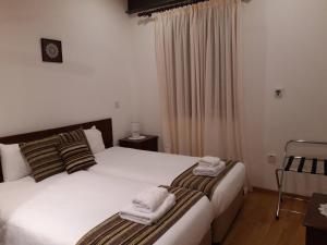 卡洛帕尼亚伊奥蒂斯阿彻蒂克伊米西尔洛酒店的一间卧室配有两张带毛巾的床