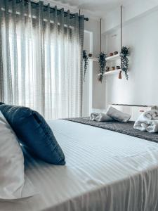 尼基季Siblings Apartments的白色卧室配有一张带蓝色枕头的大床