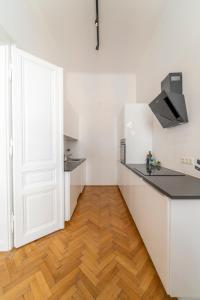 维也纳Joseph I levestate的厨房铺有木地板,配有白色橱柜。